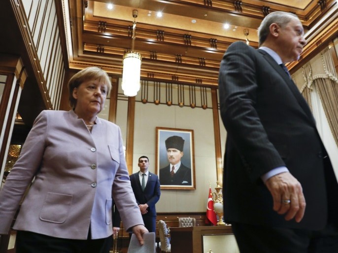 Turkish President Recep Tayyip Erdogan and German Chancellor Angela Merkel walk past a picture of Turkish Republic state founder Kemal Atatuerk before their bilateral meeting at the presidential palace during the first visit since July's failed coup in Ankara, Turkey, February 2, 2017. REUTERS/Umit Bektas
