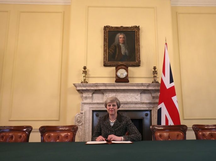 British Prime Minister Theresa May in the cabinet, sitting below a painting of Britain's first Prime Minister Robert Walpole, signs the official letter to European Council President Donald Tusk invoking Article 50 and the United Kingdom's intention to leave the EU on March 28, 2017 in London, England. After holding a referendum in June 2016 the United Kingdom voted to leave the European Union, the signing of Article 50 now officially triggers that process. REUTERS/Chr