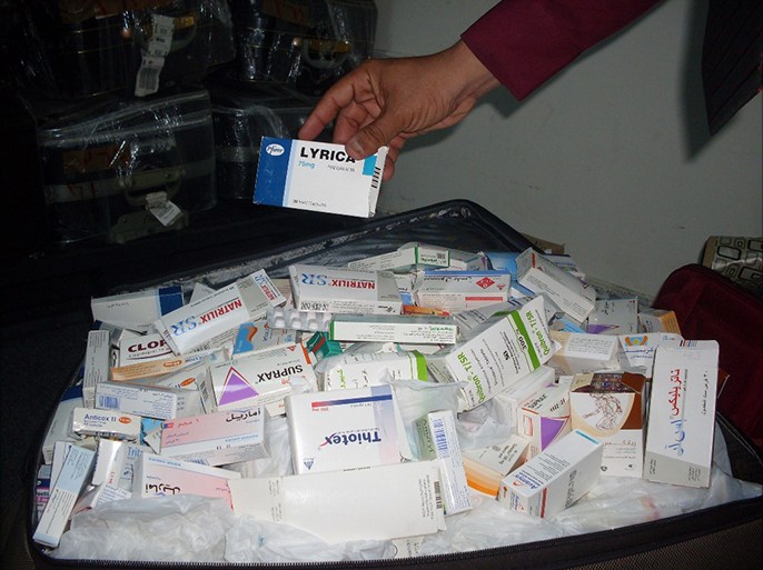 أحد العاملين في مطار عدن يستعرض للجزيرة نت أصناف من الأدوية المهربة تم ضبطها (الجزيرة)