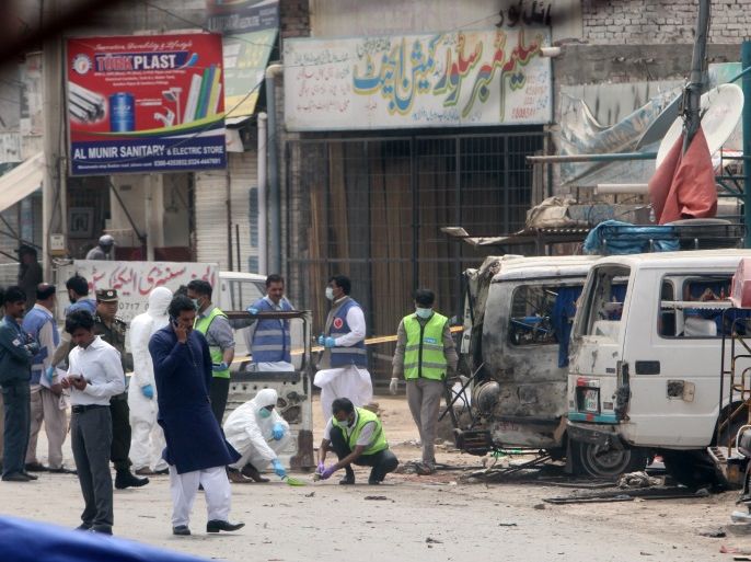 Forensic experts search for evidence at the site of an explosion, near vehicles taking part in census, in Lahore, Pakistan, April 5, 2017. REUTERS/Mohsin Raza