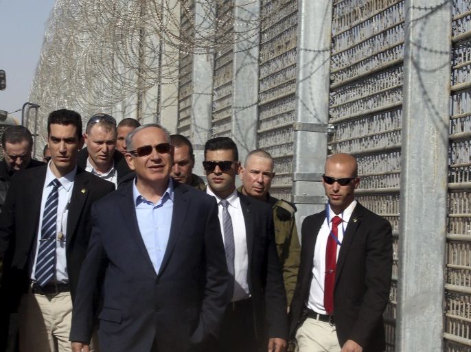 Israeli Prime Minister Benjamin Netanyahu walks next to the border fence between Israel and Jordan during a visit in southern Israel near Eilat February 9, 2016. REUTERS/Marc Israel Sellem/Pool