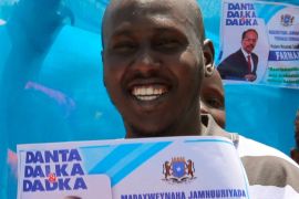 Somali journalist Abdimalik Muse Oldon holds a sign during a demonstration in support of the newly elected Somali President Mohamed Abdullahi Mohamed in Mogadishu, Somalia February 9, 2017. Picture taken February 9, 2017. REUTERS/Feisal Omar