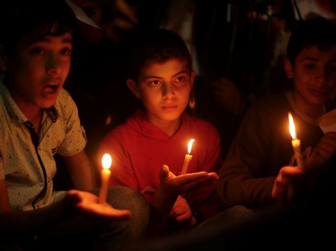 Palestinian boys hold candles during a protest against the blockade on Gaza, in Gaza City April 14, 2017. REUTERS/Mohammed Salem