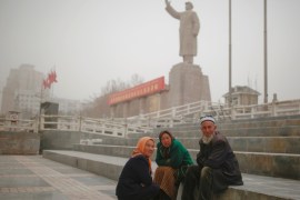 Ethnic Uighurs sit near a statue of China's late Chairman Mao Zedong in Kashgar, Xinjiang Uighur Autonomous Region, China, March 23, 2017. REUTERS/Thomas Peter SEARCH
