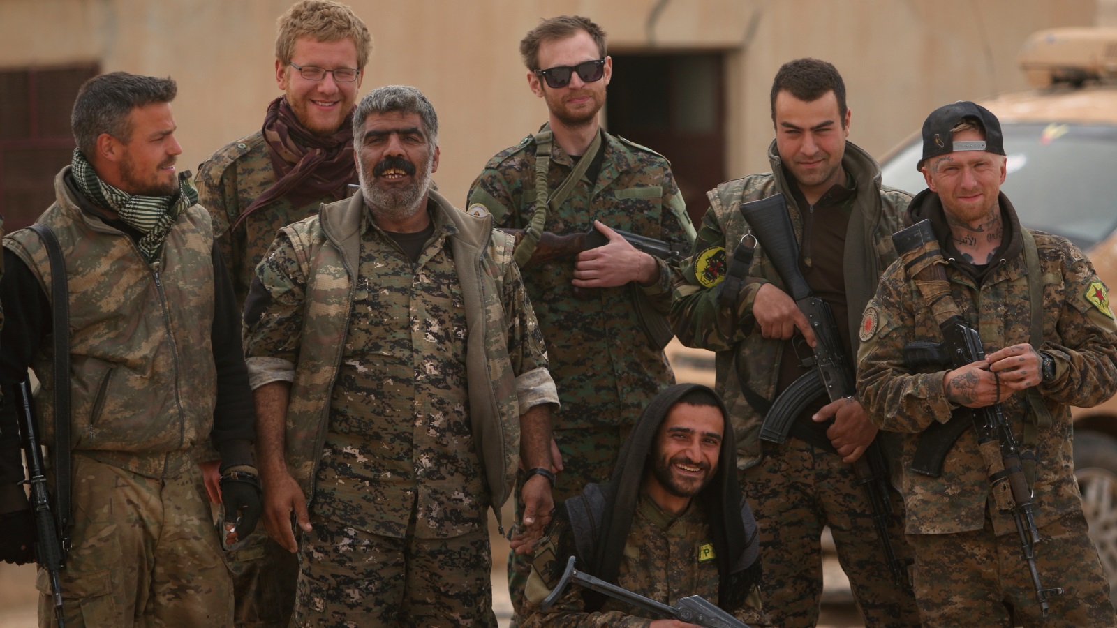 مقاتلون من قوات سوريا الديمقراطية ومقاتلون أجانب بعد السيطرة على مطار الطبقة (رويترز)