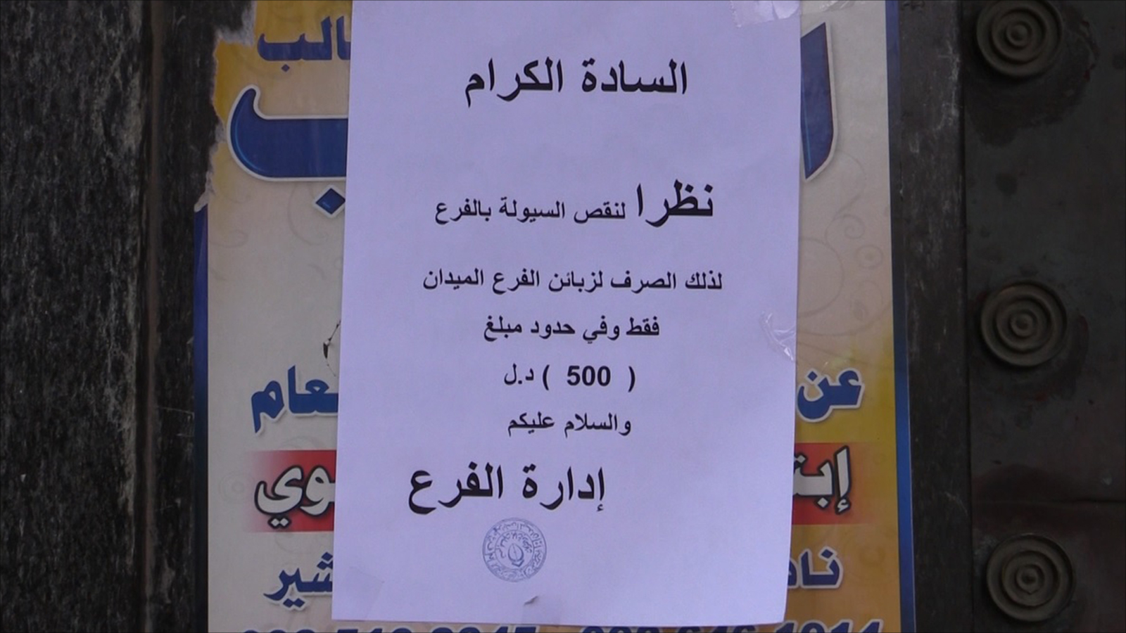 صورة إعلان لأحد المصارف في ميدان الشهداء بطرابلس عن نقص السيولة (الجزيرة)