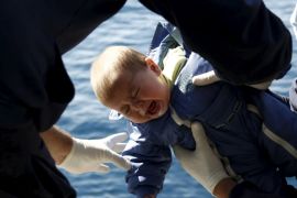 Greek Coast Guard officers move a baby from a dinghy carrying refugees and migrants aboard the Ayios Efstratios Coast Guard vessel, during a rescue operation in the open sea between the Turkish coast and the Greek island of Lesbos, February 8, 2016. REUTERS/Giorgos Moutafis