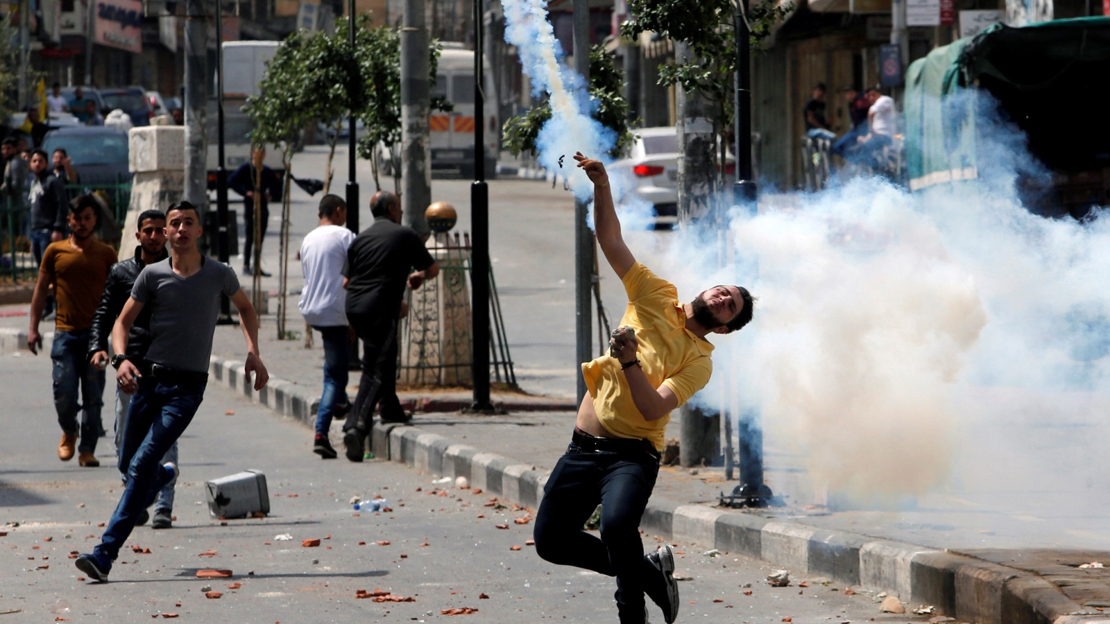 ‪شبان فلسطينيون خلال مواجهتهم قوات الاحتلال في الخليل‬ (رويترز)