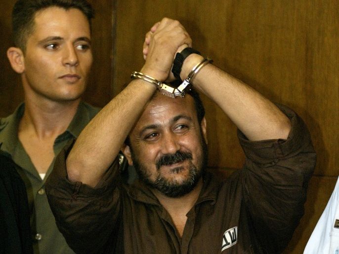 Marwan Barghouthi, 43, general secretary of Palestinian PresidentYasser Arafat's Fatah movement in the West Bank, shows his cuffed handsas he enters the Tel Aviv's city court on August 14, 2002. Shouting inHebrew,