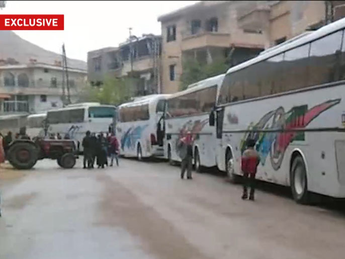 وصول حافلات لمنطقة التكية في وادي بردى بريف دمشق في وقت سابق لنقل المحاصرين (الجزيرة)
