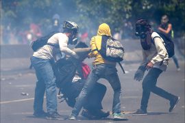 epa05916002 Demonstrators aid others during clashes with the police during an opposition protest in Caracas, Venezuela, on 19 April 2017. Venezuela is the scene of massive protests for both government supporters and opposition groups heightening tension throughout the country. EPA/CRISTIAN HERNANDEZ