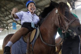 An autistic child reacts while sitting on a horse during the Horse Therapy Special Children program at the Mounted Police Sub-Division in Bangkok June 17, 2014. The program aims to help children with autism and other physical problems develop brain and body coordination and to adapt to their family and community. REUTERS/Chaiwat Subprasom (THAILAND - Tags: SOCIETY ANIMALS HEALTH CRIME LAW)