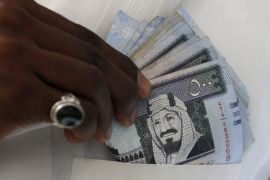 A Saudi man shows Saudi riyal banknotes at a money exchange shop, in Riyadh, Saudi Arabia January 20, 2016. REUTERS/Faisal Al Nasser