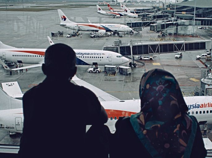 KUALA LUMPUR, MALAYSIA - JANUARY 23: A local Malay couple watch Malaysian Airlines aircraft and ground staffs in action at the busy terminal of Kuala Lumpur International airport on January 23, 2017 in Sepang, Malaysia. The families of victims onboard the missing flight MH370 said on Sunday they plan to hand deliver a petition and personal letters to Malaysian Transport Minister, Liow Tiong Lai, during his visit to Australia, urging him to resume search for the missing