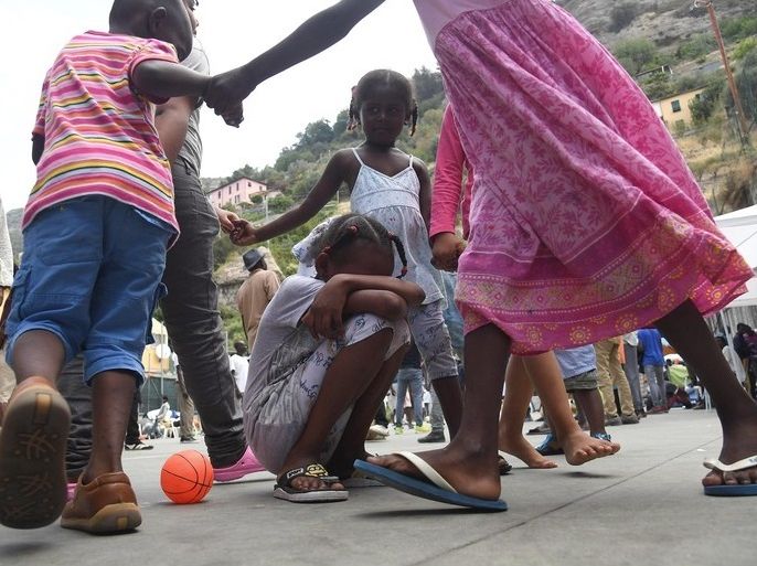 epa05415533 Migrant children play on a sports field on the premises of the Sant'Antonio Parish in Ventimiglia, Italy, 08 July 2016. A larger group of migrants is accomodated on the church's premisis with many reportedly waiting and hoping to cross the nearby border to France. EPA/LUCA ZENNARO