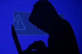 A hooded man holds a laptop computer as blue screen with an exclamation mark is projected on him in this illustration picture taken on May 13, 2017. Capitalizing on spying tools believed to have been developed by the U.S. National Security Agency, hackers staged a cyber assault with a self-spreading malware that has infected tens of thousands of computers in nearly 100 countries. REUTERS/Kacper Pempel/Illustration