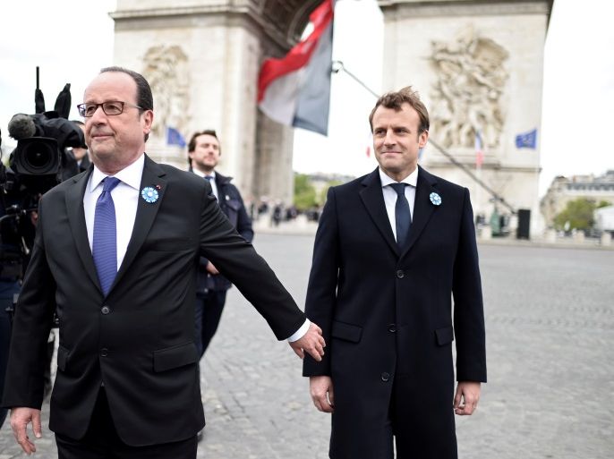 Outgoing French President Francois Hollande (L) and President-elect Emmanuel Macron attend a ceremony to mark the end of World War II at the Tomb of the Unknown Soldier at the Arc de Triomphe in Paris, France, May 8, 2017. REUTERS/Stephane De Sakutin/Pool