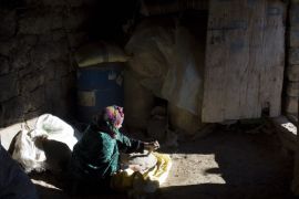 A woman prepares wheat bread in her doorway in Ait Sghir village in the High Atlas region of Morocco February 14, 2015. The snowy foothills of the High Atlas mountains in Morocco are home to several Berber villages where the inhabitants make their living by farming, baking bread in traditional ovens, herding cattle, and the making and selling of honey, olive oil and pottery. Extreme weather fluctuations and erosion that causes flooding and landslides have led to a drop in agricultural productivity, the United Nations said. REUTERS/Youssef Boudlal (MOROCCO - Tags: TRAVEL SOCIETY)ATTENTION EDITORS: PICTURE 15 OF 24 FOR WIDER IMAGE PACKAGE 'LIFE IN THE ATLAS MOUNTAINS'TO FIND ALL IMAGES SEARCH 'ATLAS BOUDLAL'