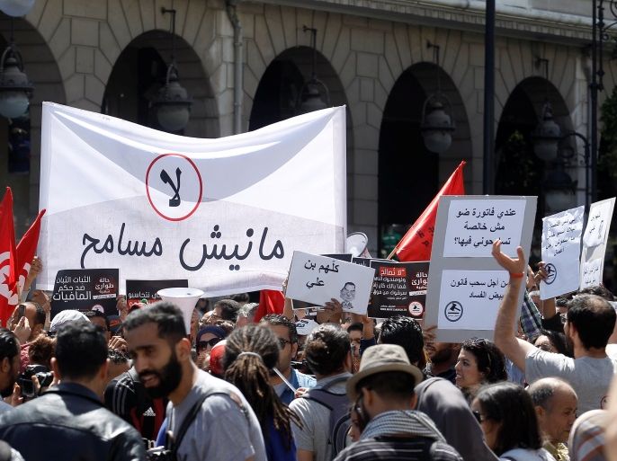 Tunisians demonstrate against a bill that would protect from prosecution those accused of corruption, on Habib Bourguiba Avenue in Tunis, Tunisia April 29, 2017. The sign reads (C)