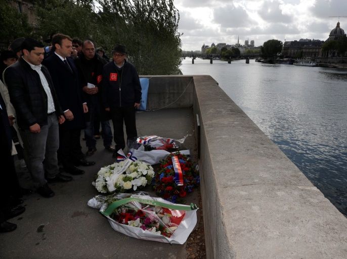 Emmanuel Macron (2ndL), head of the political movement En Marche !, or Onwards !, and candidate for the 2017 presidential election, stands next to Said Bouarram (L), son of Brahim Bouarram, as he pays hommage to Brahim Bouarram, a Moroccan who drowned in 1995 when right-wing extremists threw him from a bridge after a National Front rally, during a ceremony on the banks of the Seine River in Paris, France, May 1, 2017. REUTERS/Philippe Wojazer