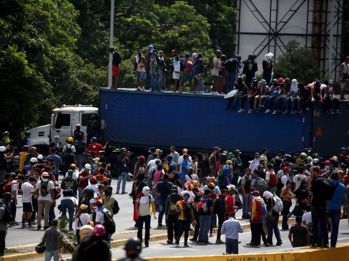 Opposition supporters temporarily block trucks during a blockade in an avenue while rallying against President Nicolas Maduro in Caracas, Venezuela, May 15, 2017. REUTERS/Carlos Garcia Rawlins