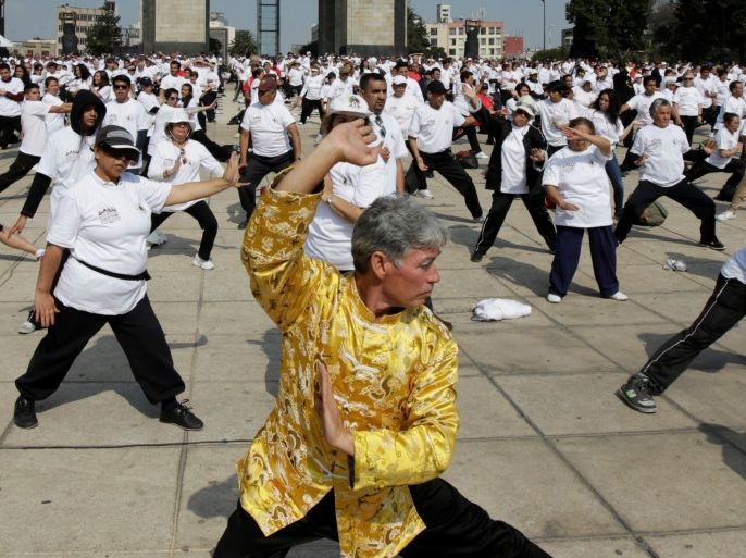 People take part in a mass Tai Chi class as part of All United for Tai Chi, a national movement to improve health, at the Revolution Monument in Mexico City, Mexico April 23, 2017. REUTERS/Jose Luis Gonzalez
