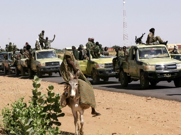 A military convoy of government forces passes a woman on a donkey, on their way to Tabit village in North Darfur November 20, 2014. The joint peacekeeping mission in the region known as UNAMID has been trying to gain access to visit Tabit since earlier this month to investigate media reports of an alleged mass rape of 200 women and girls in Tabit. Special Prosecutor for Crimes in Darfur Yasir Ahmed Mohamed and his team, accompanied by the military convoy, began initial investigations into the allegations on Wednesday. REUTERS/Mohamed Nureldin Abdallah (SUDAN - Tags: CIVIL UNREST CRIME LAW MILITARY)