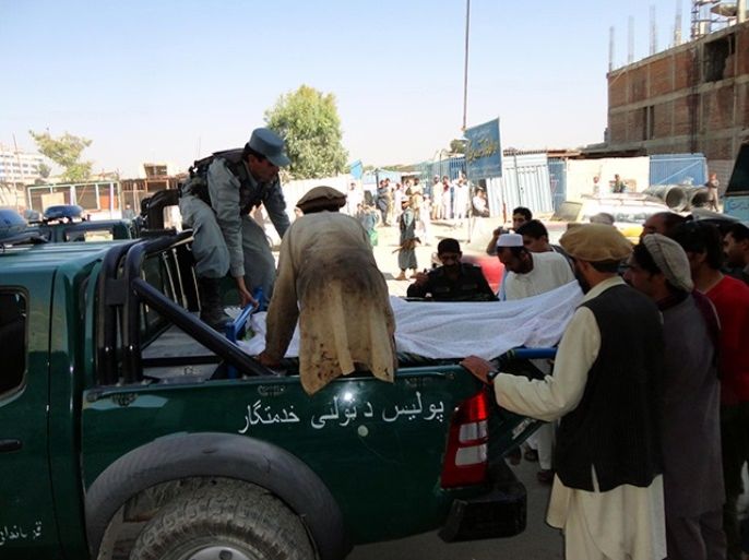 epa03416755 Afghan Police transport body of one of their comrades who was killed in a suicide bomb attack targeting a convoy of NATO's soldiers of International Security Assistance Force (ISAF) receive medical treatment at a local hospital in Khost, Afghanistan, 01 October 2012. At least 13 people including 3 NATO soldiers were killed in a suicide bombing in Khost on 01 October. EPA/SHAH NOORANI