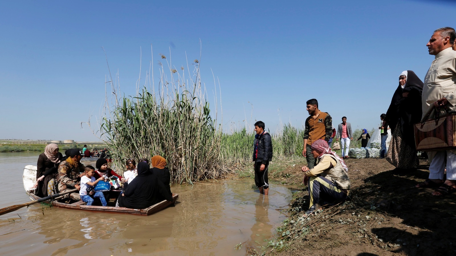 هروب عدد من المدنيين عبر نهر دجلة من القتال الدائر بين القوات العراقية وتنظيم الدولة في الشطر الغربي من الموصل (رويترز)