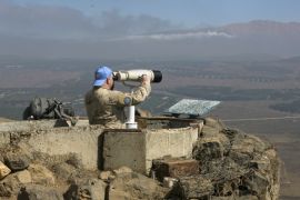 A Canadian member of the United Nations Disengagement Observer Force (UNDOF) looks through binoculars at Mount Bental, an observation post in the Israeli occupied Golan Heights near the ceasefire line between Israel and Syria August 21, 2015. Israel said it killed four Palestinian militants in an air strike on the Syrian Golan Heights on Friday, after cross-border rocket fire from Syria prompted the heaviest Israeli bombardment since the start of Syria's four-year-old civil war. REUTERS/Baz Ratner