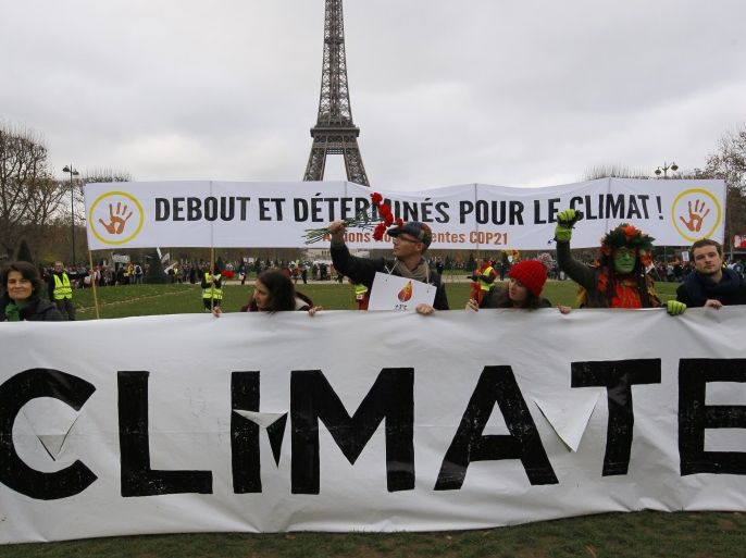 Environmentalists hold a banner which reads, 'Standing and Determined for the Climate