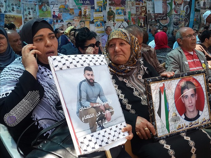 فلسطين رام الله 22 أيار 2017 فلسطينية تحمل صور نجليها وشقيقها الأسرى المضربين عن الطعام في سجون الاحتلال