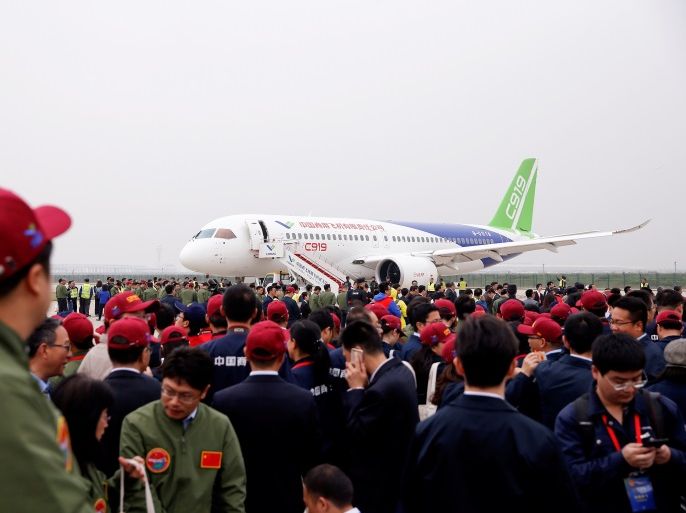 People gather around China's home-grown C919 passenger jet following its maiden flight at the Pudong International Airport in Shanghai, China May 5, 2017. REUTERS/Aly Song