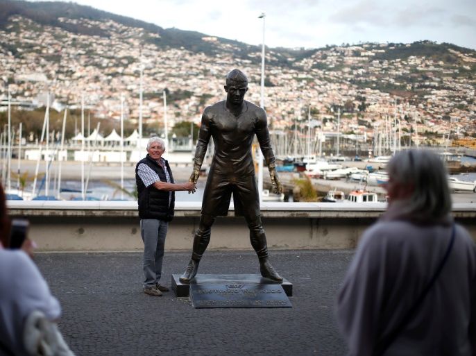 A man is photographed with the statue of Portuguese soccer player Cristiano Ronaldo in front of the CR7 museum in Funchal, Portugal March 29, 2017. REUTERS/Rafael Marchante