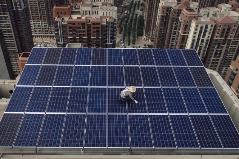 WUHAN, CHINA - MAY 15: A Chinese worker from Wuhan Guangsheng Photovoltaic Company works on a solar panel project on the roof of a 47 story building in a new development on May 15, 2017 in Wuhan, China. China consumes more electricity than any other nation, but it is also the world's biggest producer of solar energy. Capacity in China hit 77 gigawatts in 2016 which helped a 50% jump in solar power growth worldwide. China is now home to two-thirds of the world's solar