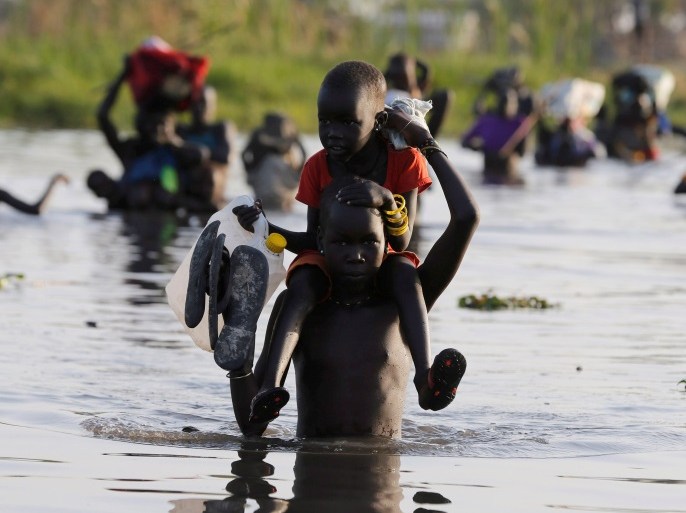 Children cross a body of water to reach a registration area prior to a food distribution carried out by the United Nations World Food Programme (WFP) in Thonyor, Leer state, South Sudan, February 25, 2017. REUTERS/Siegfried Modola