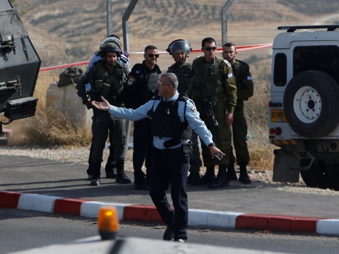 An Israeli policeman gestures at the scene where a Palestinian who was shot dead after trying to stab Israeli border police at a checkpoint north of the West Bank city of Bethlehem May 22, 2017. REUTERS/Mussa Qawasma