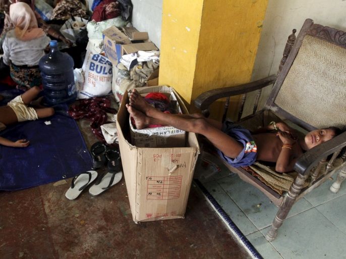 A child migrant, believed to be Rohingya, sleeps on a chair inside a shelter after being rescued from boats at Lhoksukon, in Indonesia's Aceh Province May 12, 2015. Thailand and Malaysia may set up camps and detention centers to shelter hundreds of refugees arriving on their shores, officials said on Tuesday, as a leading inter-governmental agency said about 7,000 boatpeople were still adrift in the Bay of Bengal. REUTERS/Roni Bintang