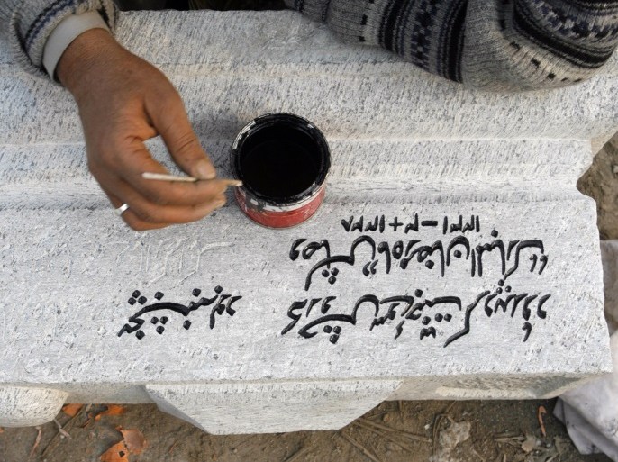 A Kashmiri worker, Ghulam Rasool, writes a Persian couplet on a gravestone at Kashmir's biggest graveyard in downtown Srinagar November 26, 2007. REUTERS/Fayaz Kabli (INDIAN-ADMINISTERED KASHMIR)
