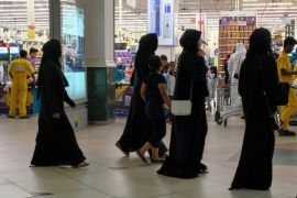 Women walk at a supermarket as people buy foodstuff in Doha, Qatar