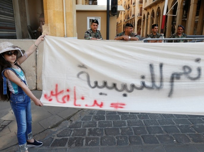 A girl holds a banner during a demonstration against an extension of the parliament's term, in Beirut, Lebanon May 6, 2017. Picture taken May 6, 2017. To match Analysis LEBANON-POLITICS/ REUTERS/Mohamed Azakir