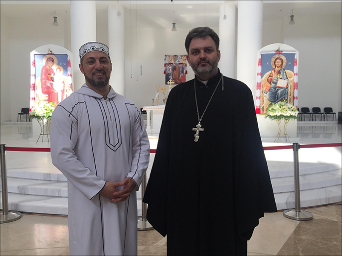الداعية سرحان مع أحد قساوسة الكنيسة الكاثوليكية في كييف (الجزيرة)