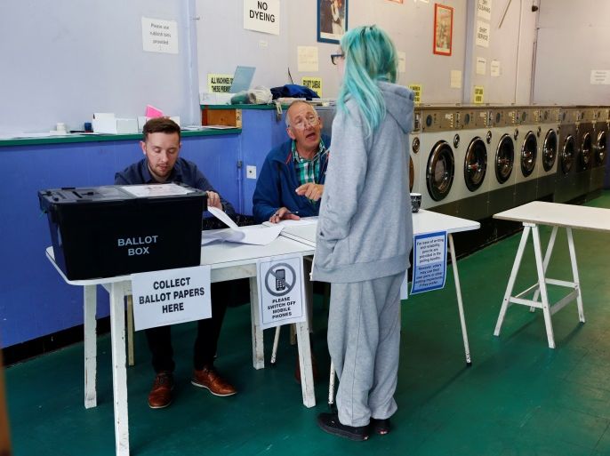 A woman votes at a laundrette used as a temporary polling station in Oxford , Britain, June 8, 2017. REUTERS/Eddie Keogh
