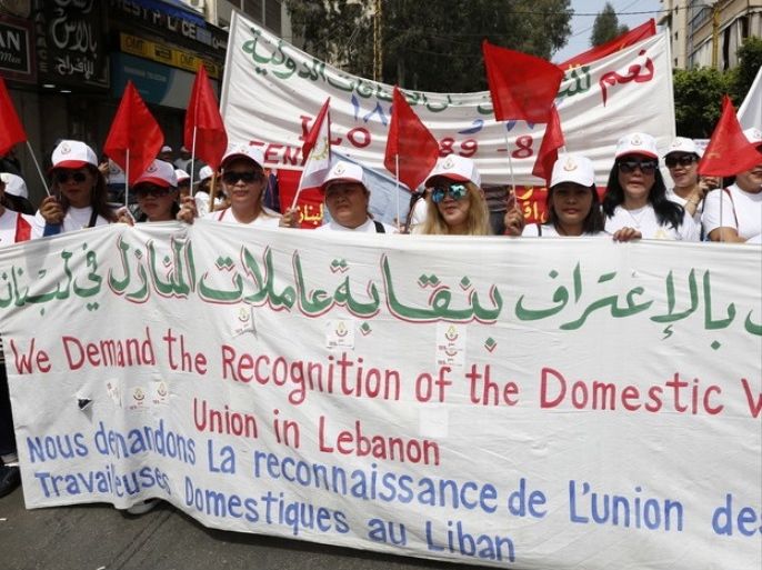 epa05938883 Women from Asian and African countries working as domestic workers carry their national flags and placards demanding better work conditions such as minimum wage, during a demonstration organized by the Lebanese Communist Party to mark international Labour Day, where they march from Cola area to the down town of Beirut, Lebanon, 01 May 2017. Labor Day is an annual holiday celebrated all over the world that resulted from efforts of the labor union movement, to celebrate the economic and social achievements of workers. EPA/NABIL MOUNZER