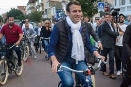 rench President Emmanuel Macron (C) and his wife Brigitte Trogneux (L) leave home on bicycles the day before the first round of the French legislatives