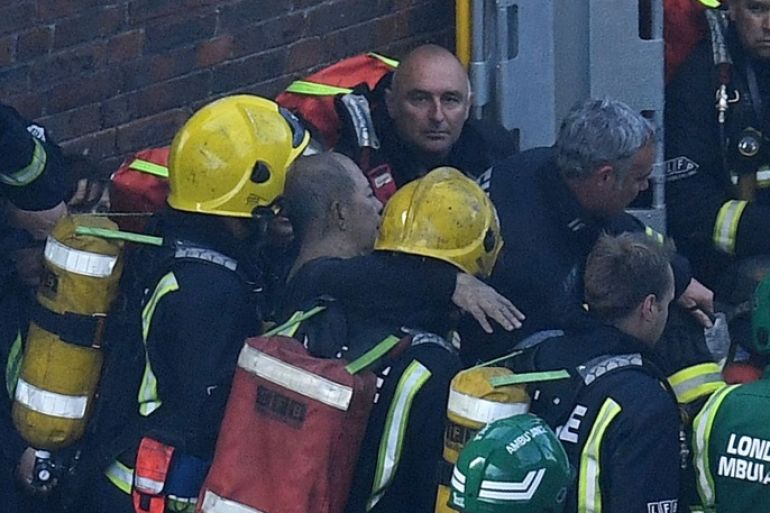 LONDON, ENGLAND - JUNE 14: A man is rescued by fire fighters after a huge fire engulfed the 24 storey residential Grenfell Tower block in Latimer Road, West London in the early hours of this morning on June 14, 2017 in London, England. The Mayor of London, Sadiq Khan, has declared the fire a major incident as more than 200 firefighters are still tackling the blaze while at least 50 people are receiving hospital treatment. (Photo by Leon Neal/Getty Images)