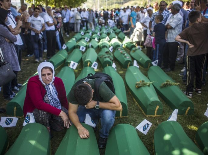 SREBRENICA, BOSNIA AND HERZEGOVINA - JULY 11: People mourn over the coffin before the mass funeral for 136 newly-identified victims of the 1995 Srebrenica massacre attended by tens of thousands of mourners during the 20th anniversary of the massacre at the Potocari cemetery and memorial on July 11, 2015 in Srebrenica, Bosnia and Herzegovina. At least 8,300 Bosnian Muslim men and boys who had sought safe heaven at the U.N.-protected enclave at Srebrenica were killed by members of the Republic of Serbia (Republika Srpska) army under the leadership of General Ratko Mladic, who is currently facing charges of war crimes at The Hague, during the Bosnian war in 1995. (Photo by Matej Divizna/Getty Images)