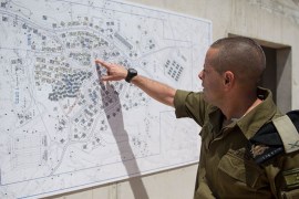 ضابط بالجيش الإسرائيلي يستعرض خريطة المدينة العسكرية التي أقيمت بالجولان السوري المحتل من أصل 3 مدن تقام بالنقب وحيفا لتحديث تدريبات وحدات الجيش.