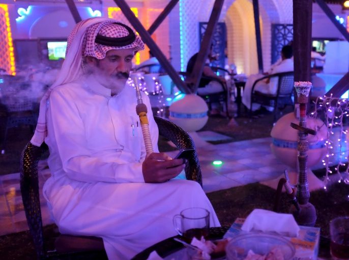 A Saudi man uses his smartphone as he smokes water pipe at a cafe in Dammam, Saudi Arabia March 7, 2016. REUTERS/Zuhair Al-Traifi