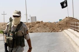 ميدان - جندي كردي وخلفه علم تنظيم الدولة